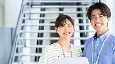 階段の前で微笑む二人の人物。
