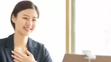 スーツを着た人が机でビデオ通話をしている