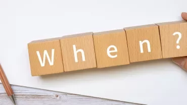 木のブロックに「When?」と書かれている。ペンが横にある。